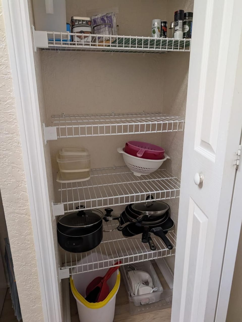 closet with frying pans, 2 griddles, electric tea kettles, bowls, tuperware, pot