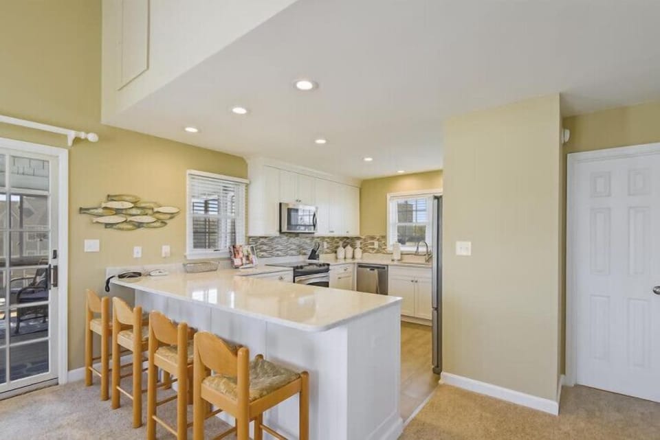 Step into your bright, open kitchen with a central island perfect for meal prep and casual dining. White cabinetry and modern appliances make cooking a breeze.