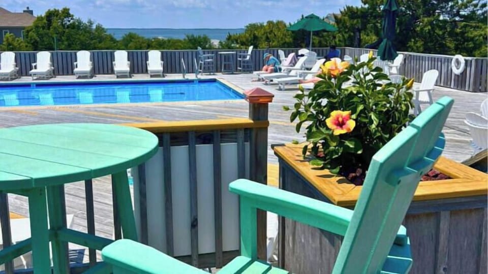 Relax by your sparkling community pool, where turquoise chairs invite you to soak up the sun and distant ocean views stretch to the horizon.