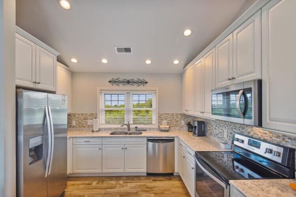 Your fully equipped kitchen awaits, featuring stainless appliances, granite countertops, and plenty of cabinet space for all your culinary adventures during your stay.