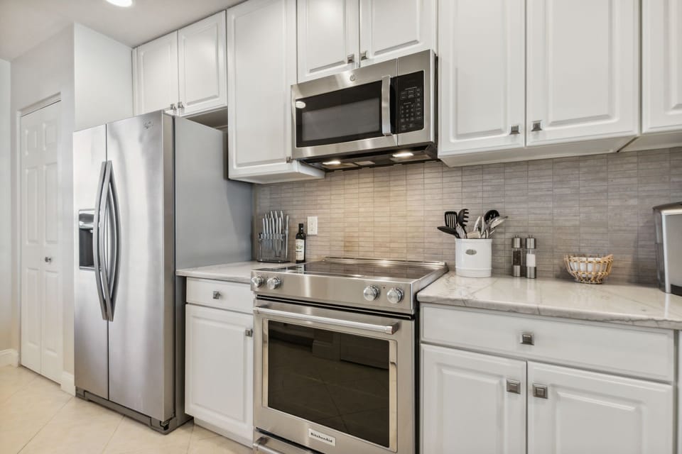 Fully Equipped Kitchen with Stainless Steel Appliances, Handsome Granite Countertops, Wine Cooler, and Bar Area