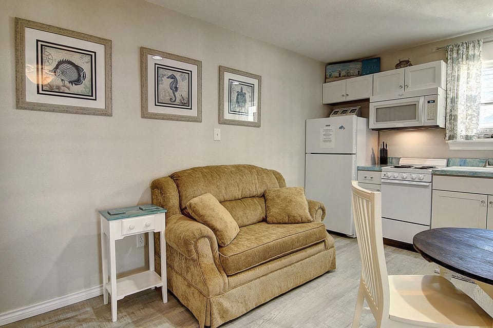 Relax in your cozy living space where coastal charm meets comfort, featuring a plush loveseat perfect for unwinding after beach adventures.