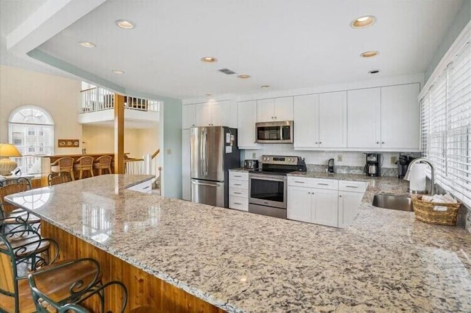 Your gourmet kitchen awaits with gleaming granite counters, stainless appliances, and an expansive island perfect for meal prep or morning coffee with loved ones.