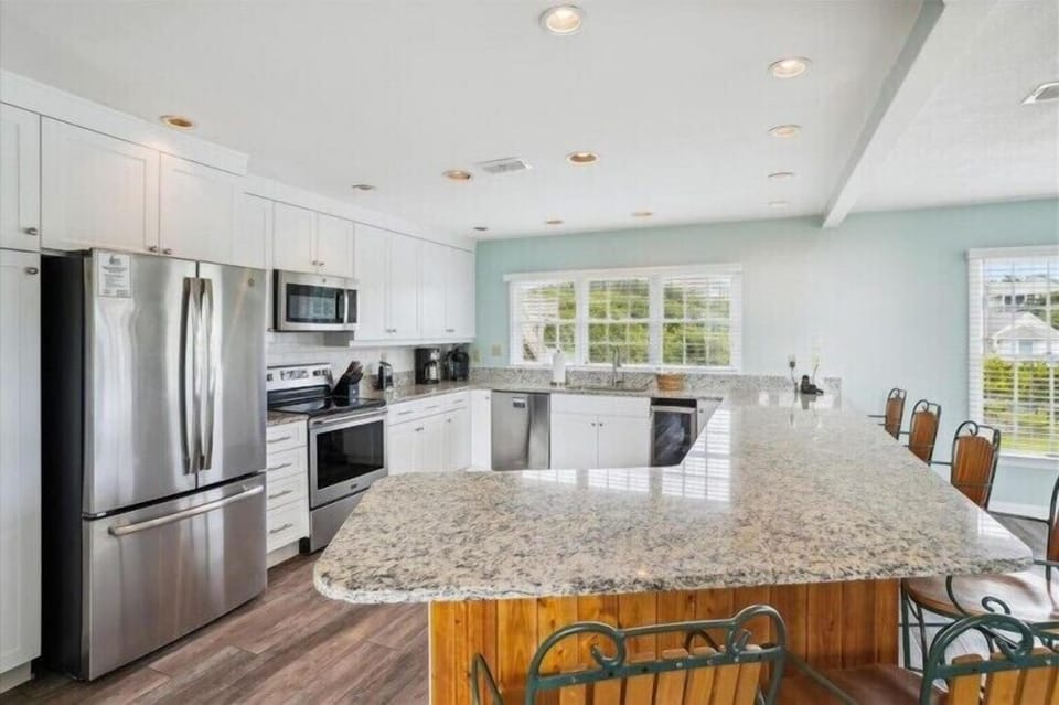 Cook your favorite meals in this spacious, sunlit kitchen featuring granite counters, stainless appliances, and white cabinetry—perfect for gathering with loved ones.
