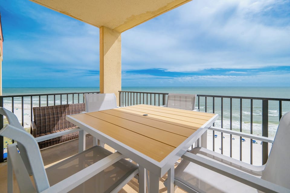 Enjoy meals or drinks at the outdoor dining set with a view of the beach and tranquil waters from the private balcony