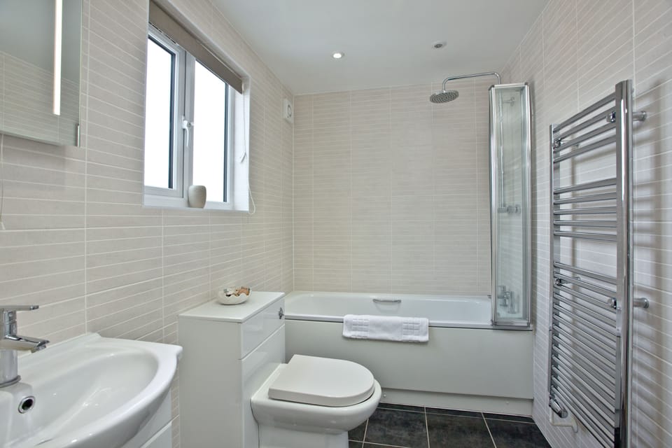 Bathroom with toilet, bathtub and overhead shower, heated towel rail  - Sunnymead