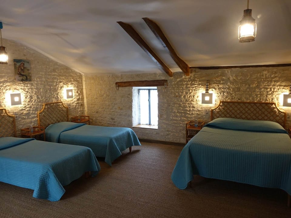 Une grande chambre familiale avec du mobilier en fibres naturelles