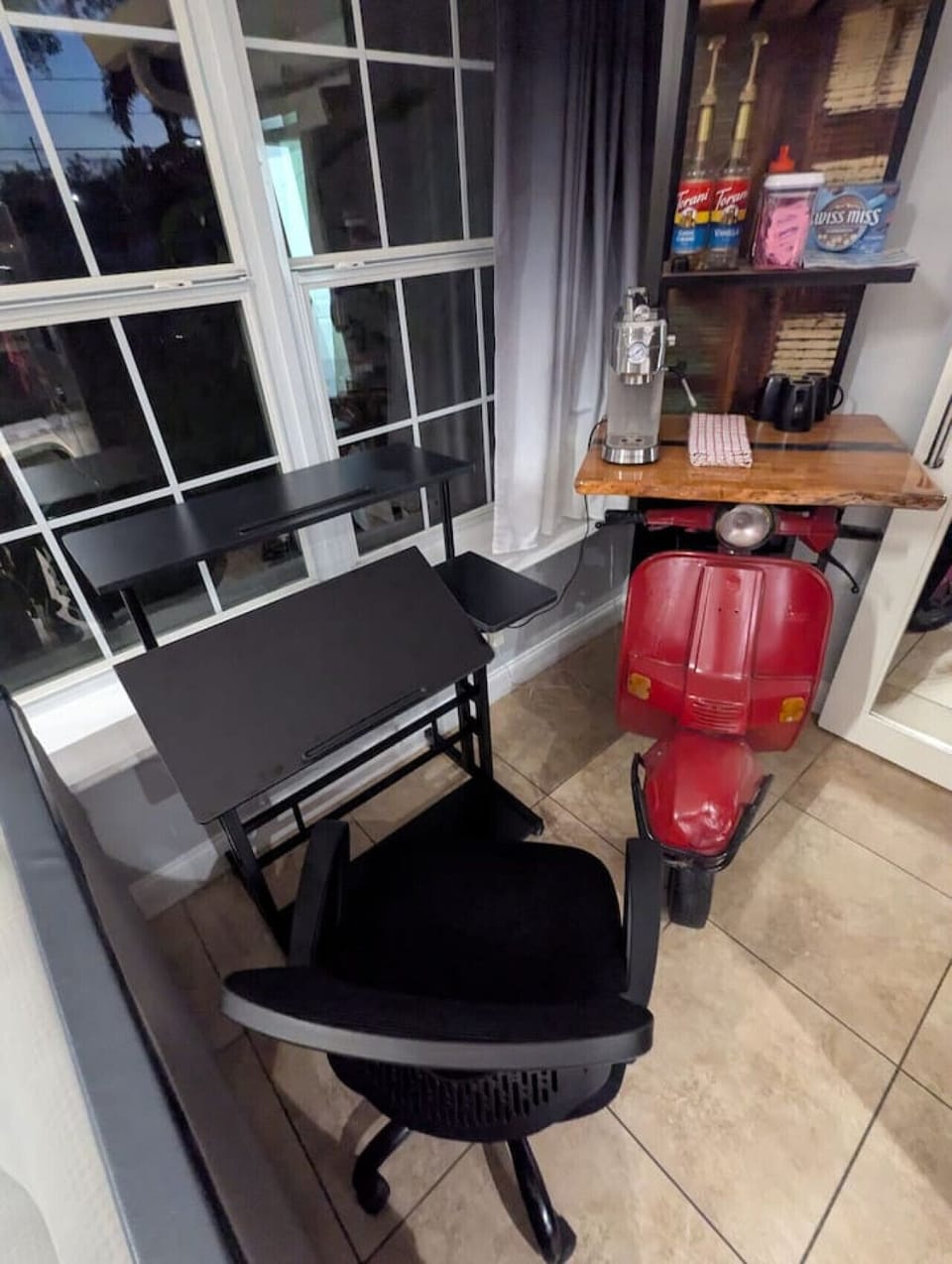 Unique indoor coffee and bar station with vintage red Vespa scooter, black table and large windows, Private Luxury Smart-home Orlando
