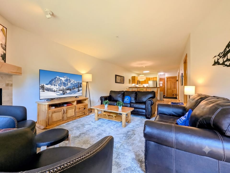 Sink into plush leather seating and unwind in your spacious living room, complete with a large TV and an inviting open layout that flows into the fully equipped kitchen.