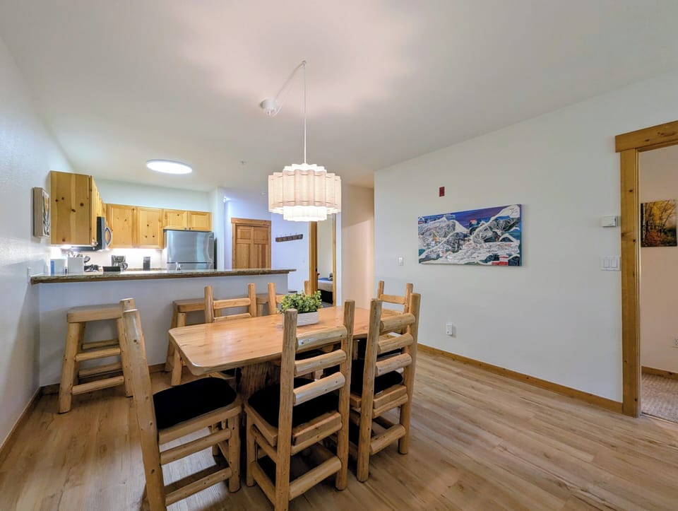 Gather around the handcrafted wooden dining table, where rustic charm meets modern comfort. The open-concept layout flows seamlessly into your kitchen, making every meal feel warm and connected.