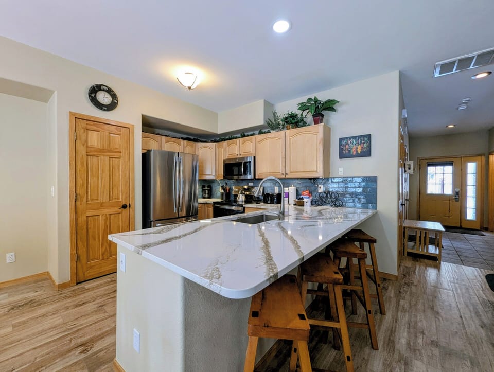 Your gourmet kitchen awaits with gleaming countertops, modern appliances, and a breakfast bar perfect for morning coffee or casual dining.
