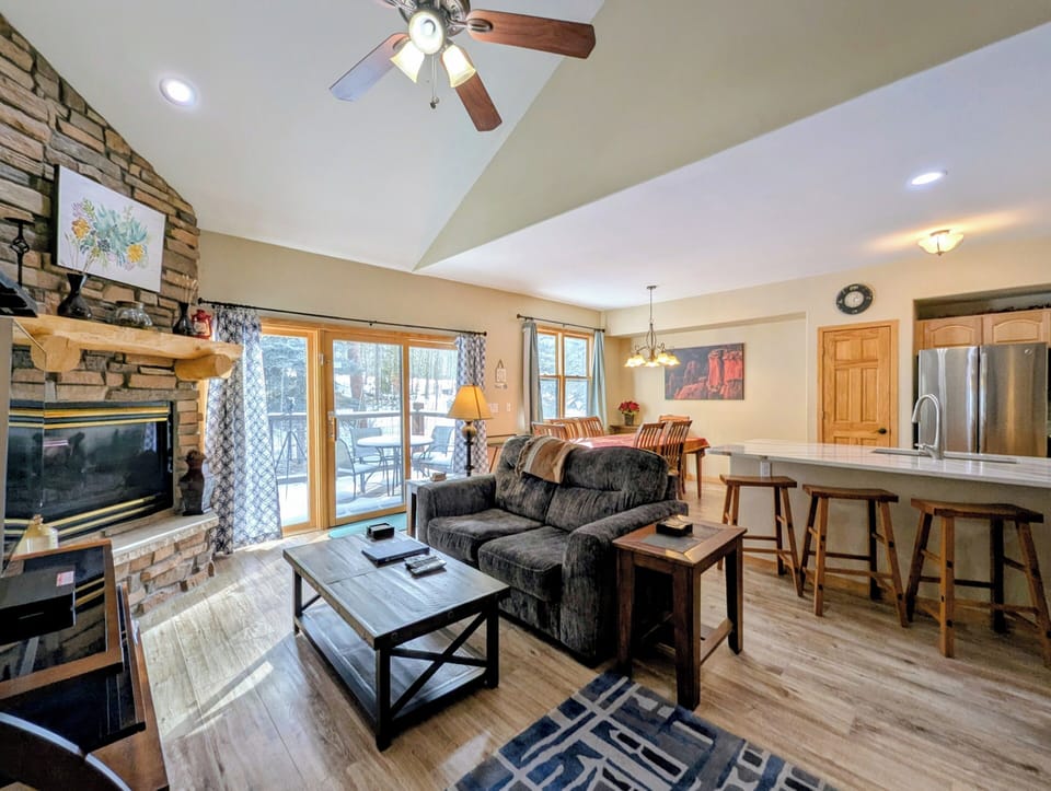 Relax in your open-concept retreat with soaring vaulted ceilings, cozy stone fireplace, and seamless flow between living and dining spaces.