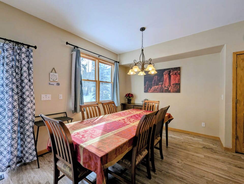 Gather around this welcoming dining table where warm wood meets mountain charm. Your family meals await in this cozy space.