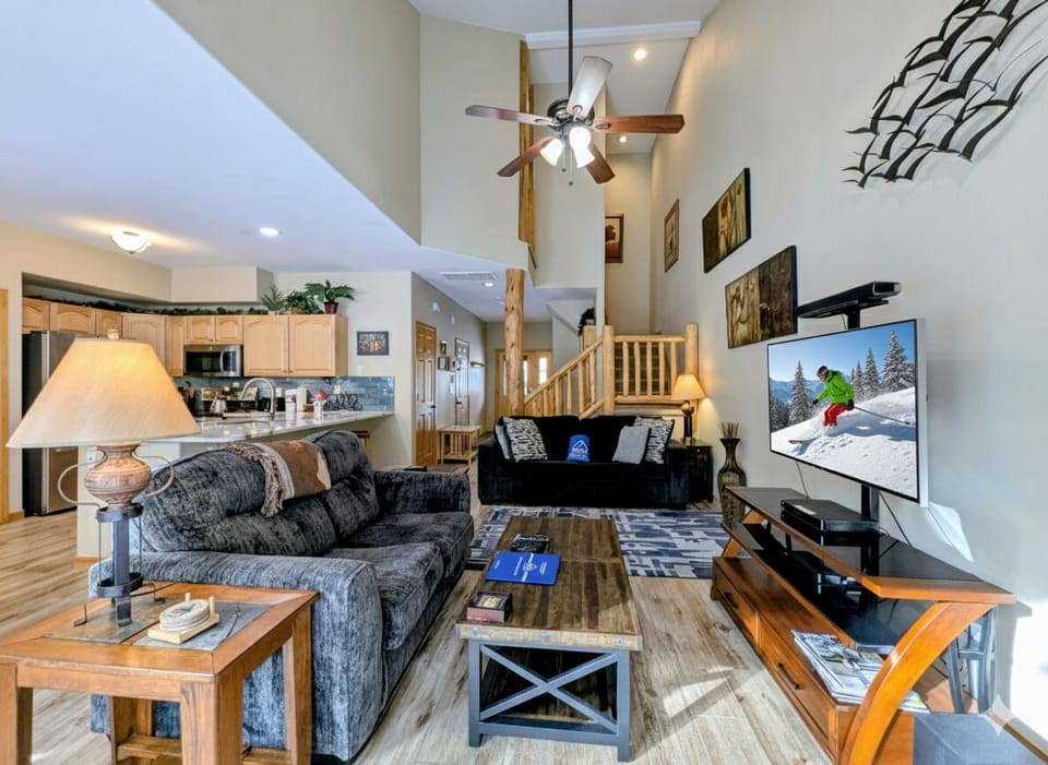 Relax in your spacious living room with plush seating, warm wood details, and a large TV perfect for cozy movie nights.