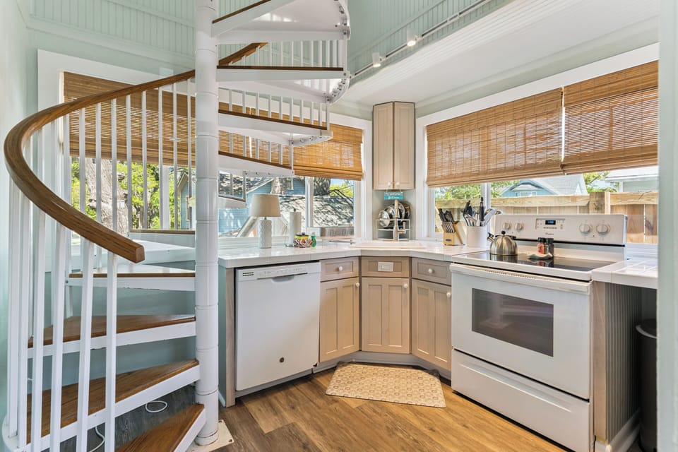 Your bright kitchen features stainless steel appliances and spiral stairs, perfect for preparing meals in this airy, well-equipped space.