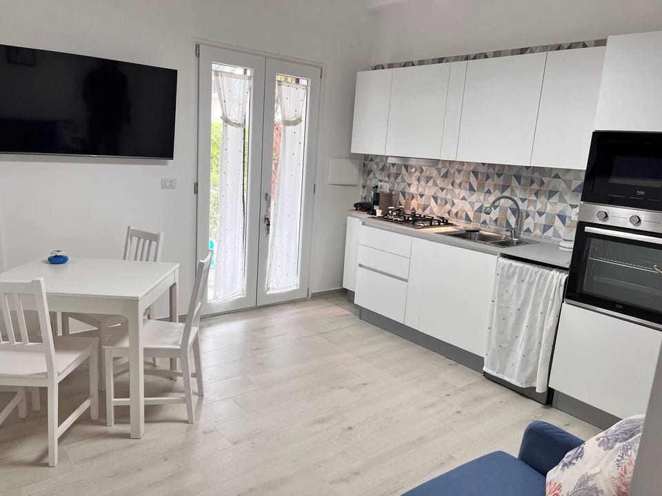 Zona living con divano e TV a schermo piatto.