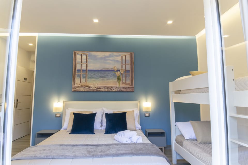 Deluxe Quadruple Room, City View (Stanza Acqua) | Premium bedding, down comforters, memory foam beds, minibar