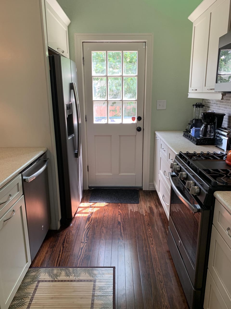 Door leads to deck in side yard with outdoor dining and lounge chairs.