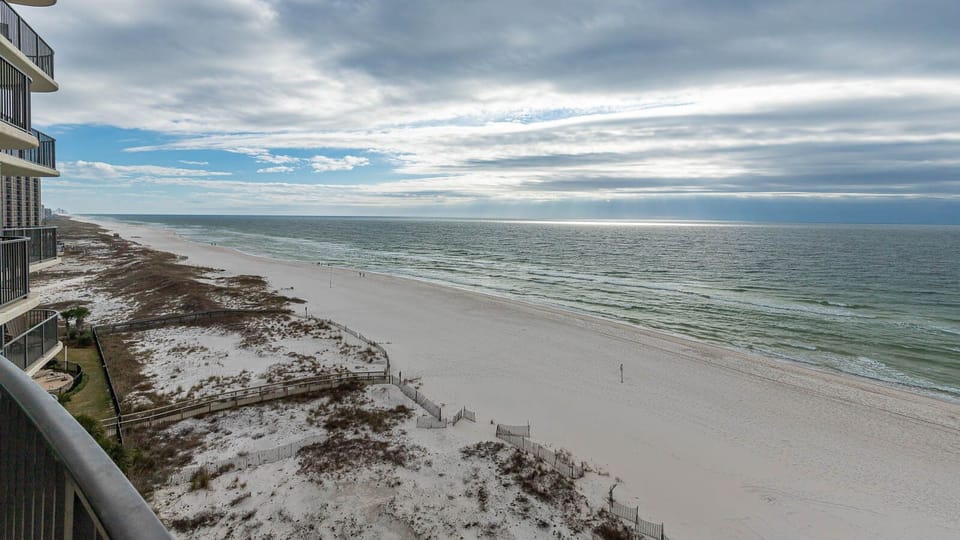 Breathe in the fresh air from your balcony, overlooking the beach and gentle waves stretching into the horizon