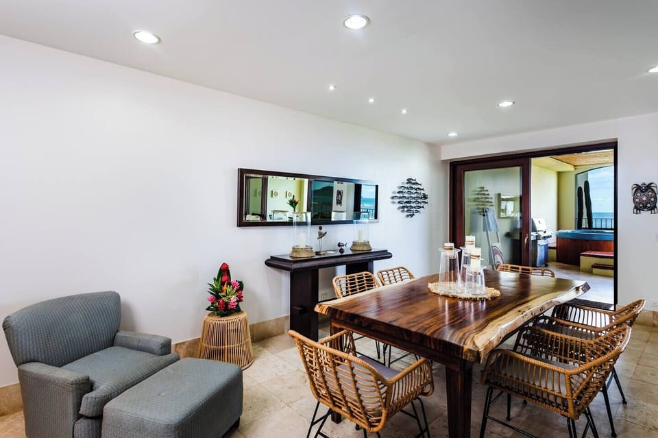 Handcrafted Costa Rican wood dining table with seating for six, set in a bright open space with tropical decor. Perfect for family meals, sunset dinners, or remote work in this beachfront Langosta condo near Tamarindo.