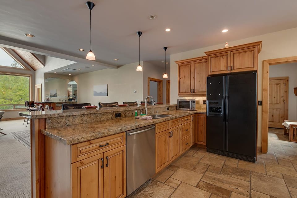 - Spacious kitchen with granite counters and modern appliances  
- Large layout includes breakfast bar and wood cabinetry  
- Perfect for cooking and entertaining with open design