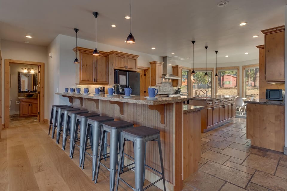 - Kitchen breakfast bar with multiple stools for casual dining  
- Overlooks open concept space for easy entertaining and meals  
- Stylish pendant lighting enhances rustic modern charm