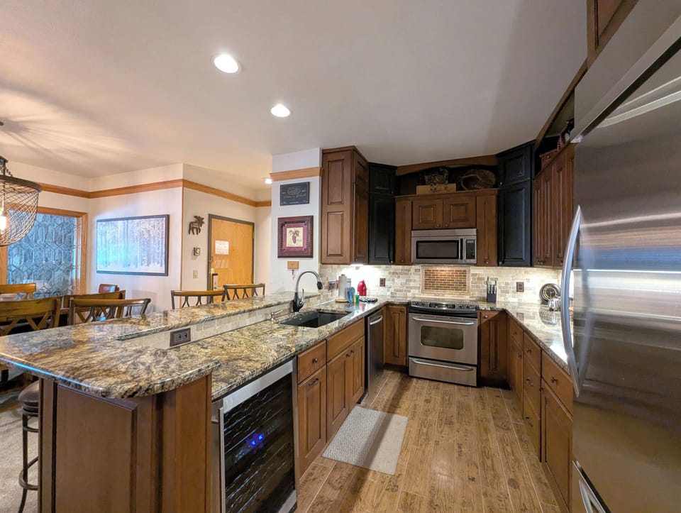 Prepare memorable meals in this spacious kitchen featuring granite countertops, stainless appliances, and a wine fridge!