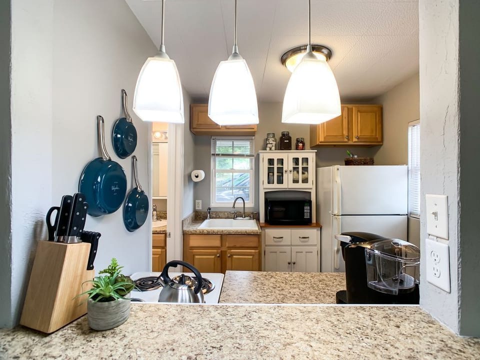 Compact kitchen thoughtfully equipped with a full-size fridge, 4 burner stove, breakfast bar and everything you need to prepare meals.