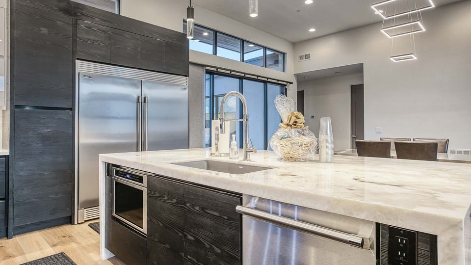 Kitchen with pro appliances, marble accents & under-cabinet lighting.

