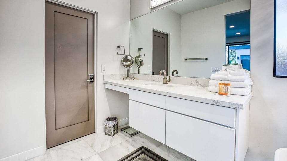 Sleek double vanity with modern design, marble floors & ample storage.
