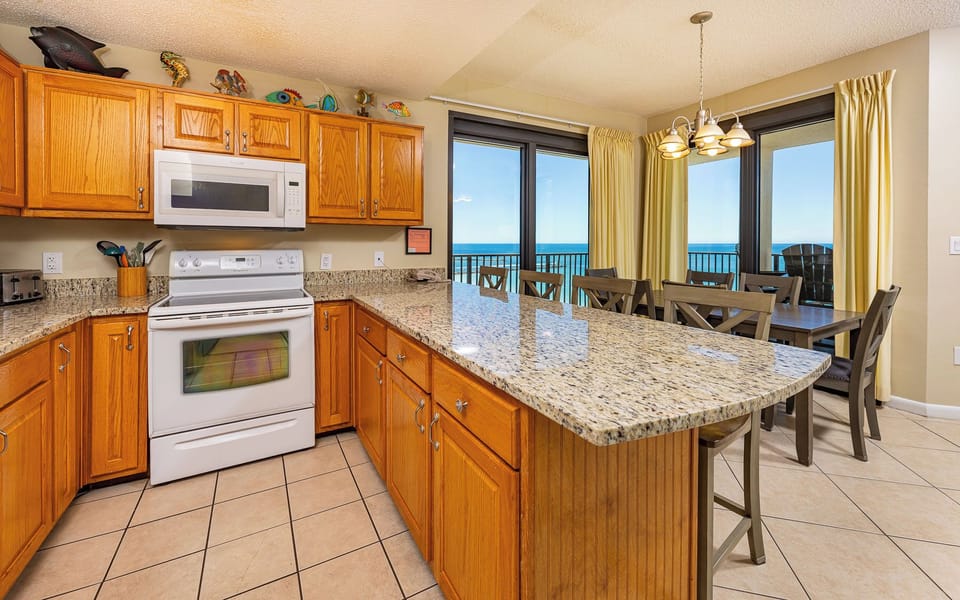 Sunlight glints off granite counters as you prepare meals with cheerful coastal decor nearby in the kitchen