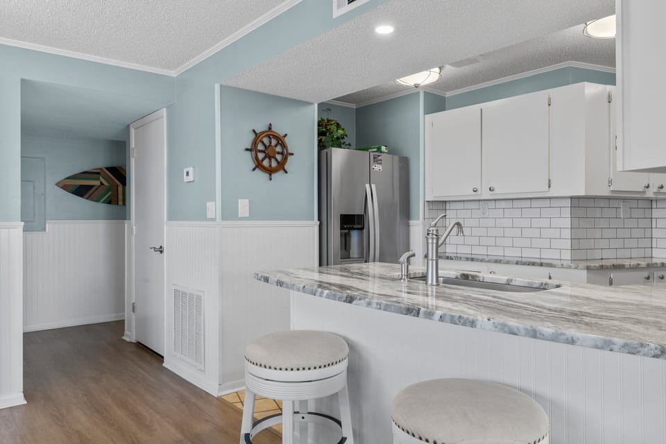 Counter height barstools for sitting area at granite countertop.