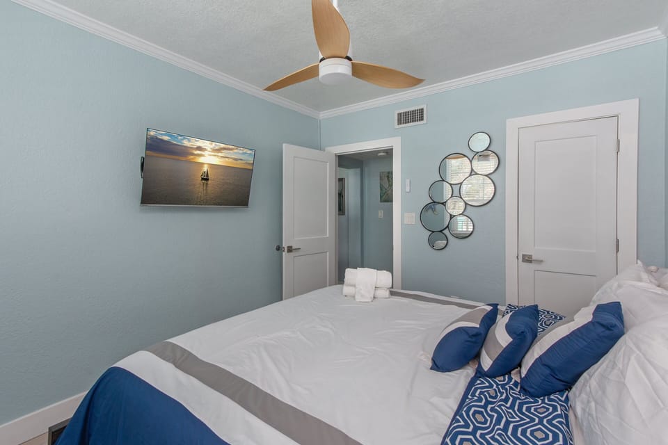 Primary Bedroom: A serene sanctuary featuring a King-sized bed, smart TV and a ceiling fan.