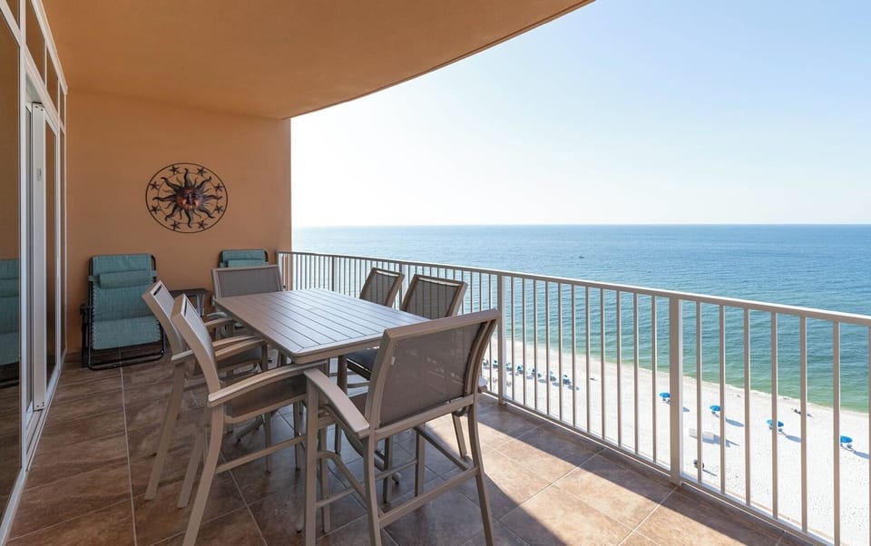 Delight in the gentle coastal breeze as you relax around the balcony table, savoring stunning beach views