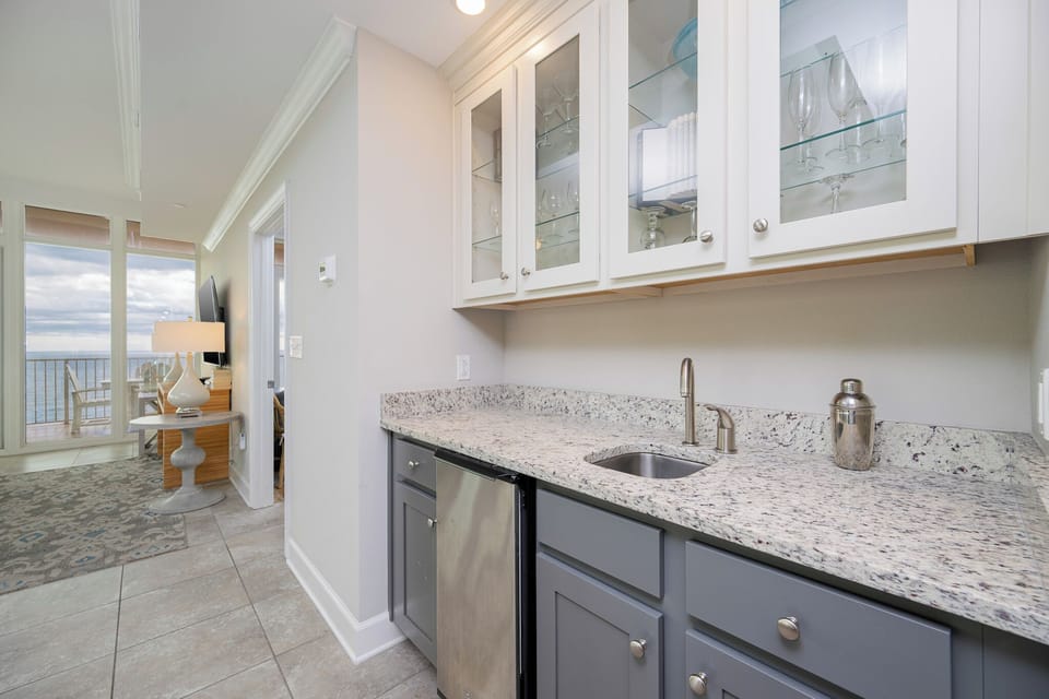 Grab a chilled drink from the fridge or create your favorite cocktail at the wet bar with elegant glassware displays