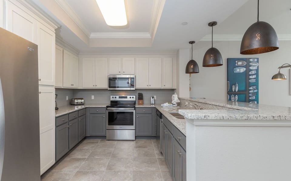 Enjoy creating culinary delights in this stylish kitchen, illuminated by elegant pendant lighting and modern design