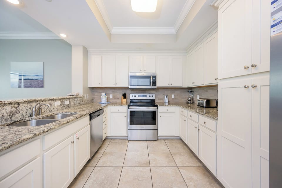 Prepare meals in this kitchen with elegant cabinetry, stainless appliances, and stylish backsplash