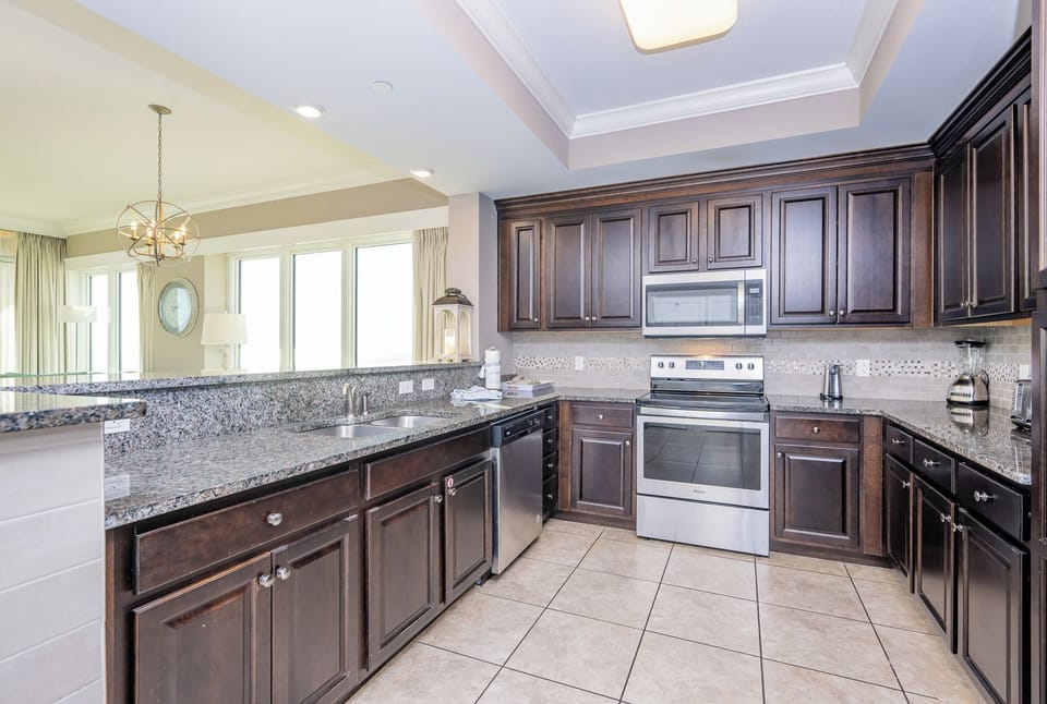 Prepare meals in this kitchen with elegant cabinetry, stainless appliances, and stylish backsplash