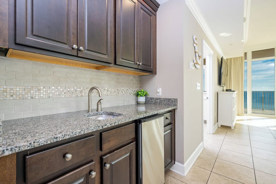 Grab a chilled drink from the fridge or create your favorite cocktail at the wet bar with elegant glassware displays