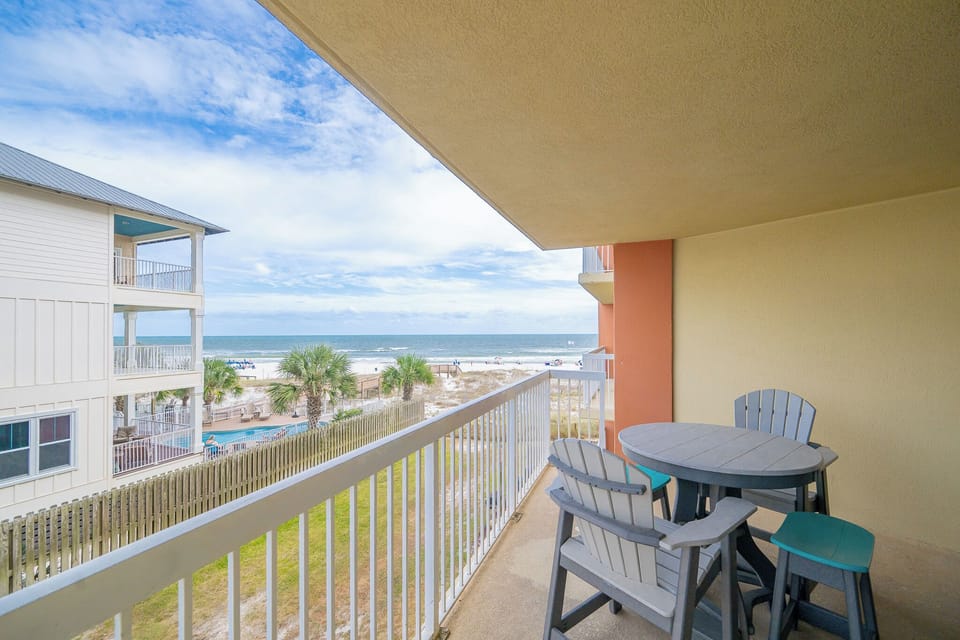 Relax on the private balcony with comfortable seating and enjoy the beautiful coastal view just steps from the beach
