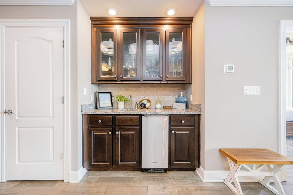 Grab a chilled drink from the fridge or create your favorite cocktail at the wet bar with elegant glassware displays