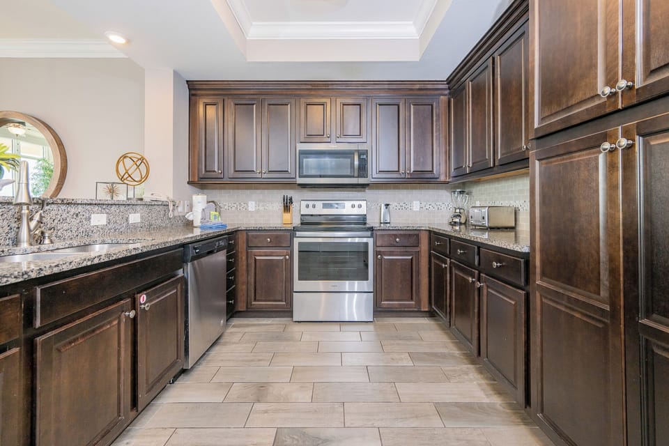 Prepare meals in this kitchen with elegant cabinetry, stainless appliances, and stylish backsplash
