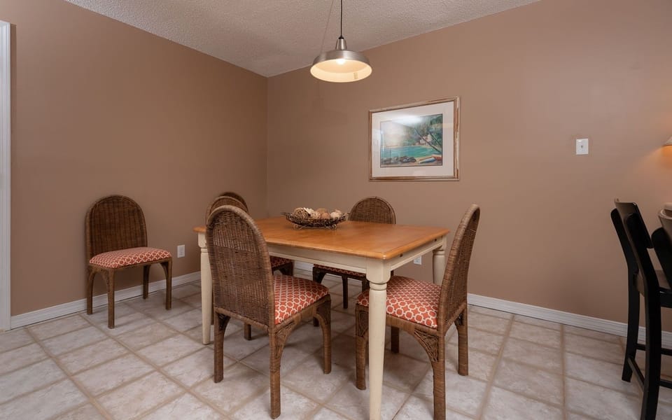 This dining area features a warm color palette, a wooden table, and stylish wicker chairs, perfect for shared meals