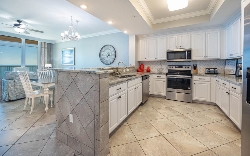 Prepare meals in this kitchen with elegant cabinetry, stainless appliances, and stylish backsplash