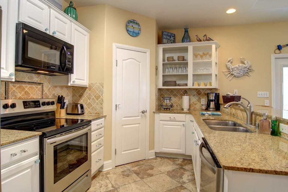 The kitchen has freshly painted cabinets and a walk-in pantry.