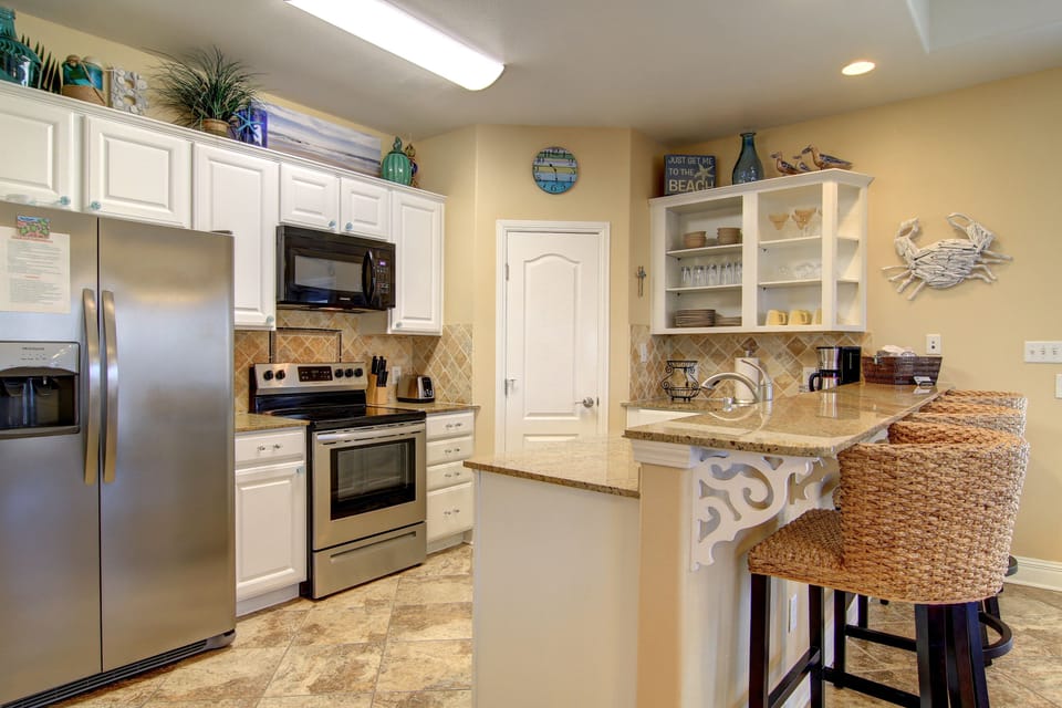 The kitchen is fully stocked with cookware, utensils, dishes, cups & linens.