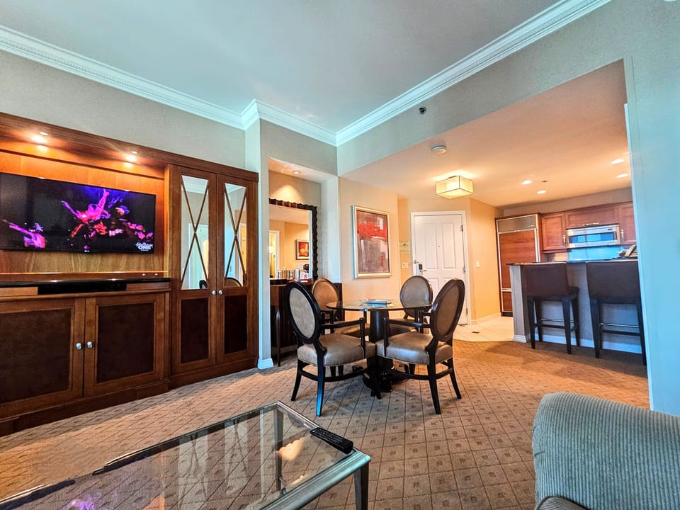 Open living room, dining table, bar seating and kitchen.