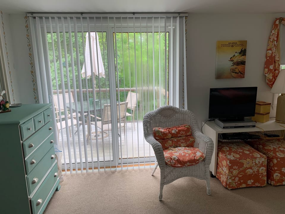 Dresser and sliders to deck in twin bedroom, fireplace heater not shown