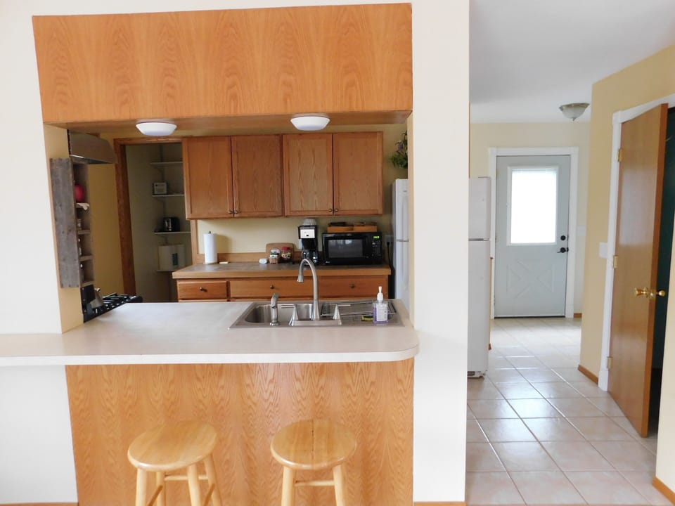 View of kitchen and front door, with bathroom on the right.
