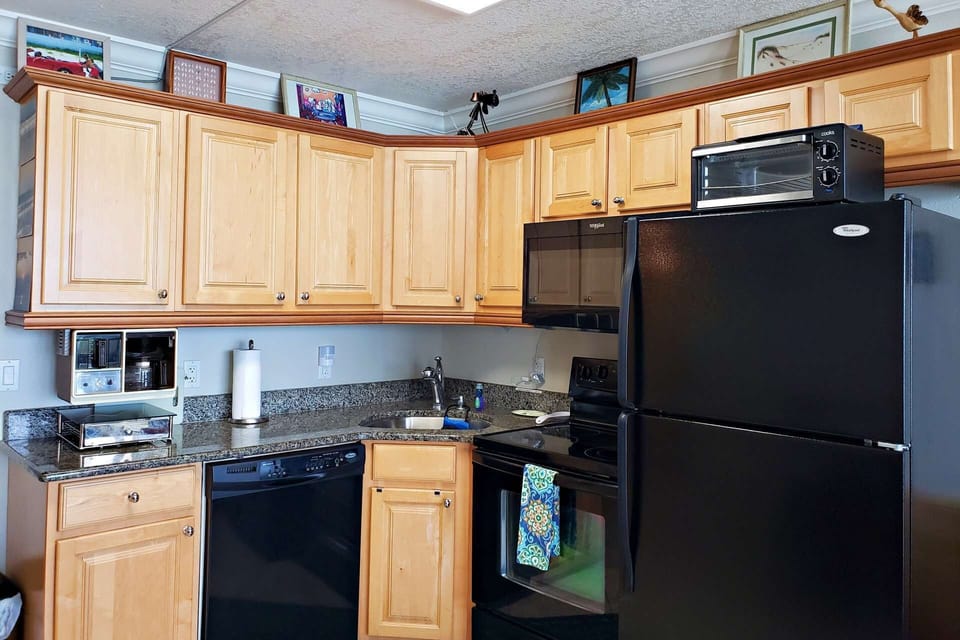 Kitchen has full refrigerator w/ ice-maker, dishwasher, stove / oven, microwave, toaster oven & coffee maker.